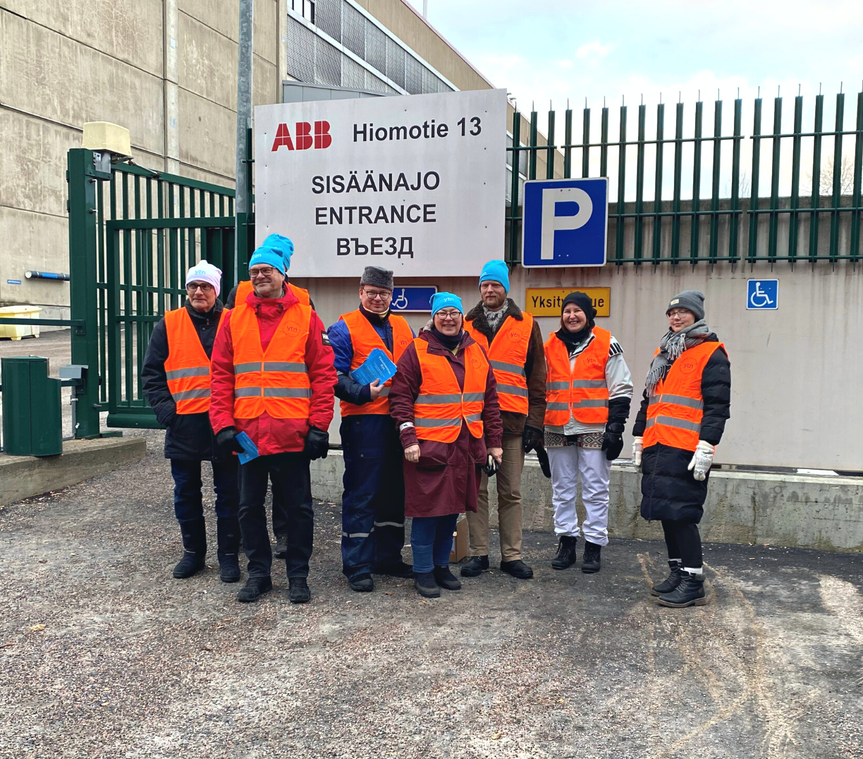 People in strike in front of a factory gate.