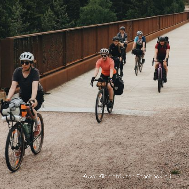 Polkupyöräilijöitä sillalla.