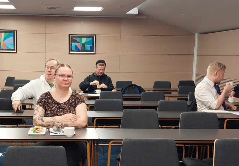 Ihmisiä kokoustilassa.