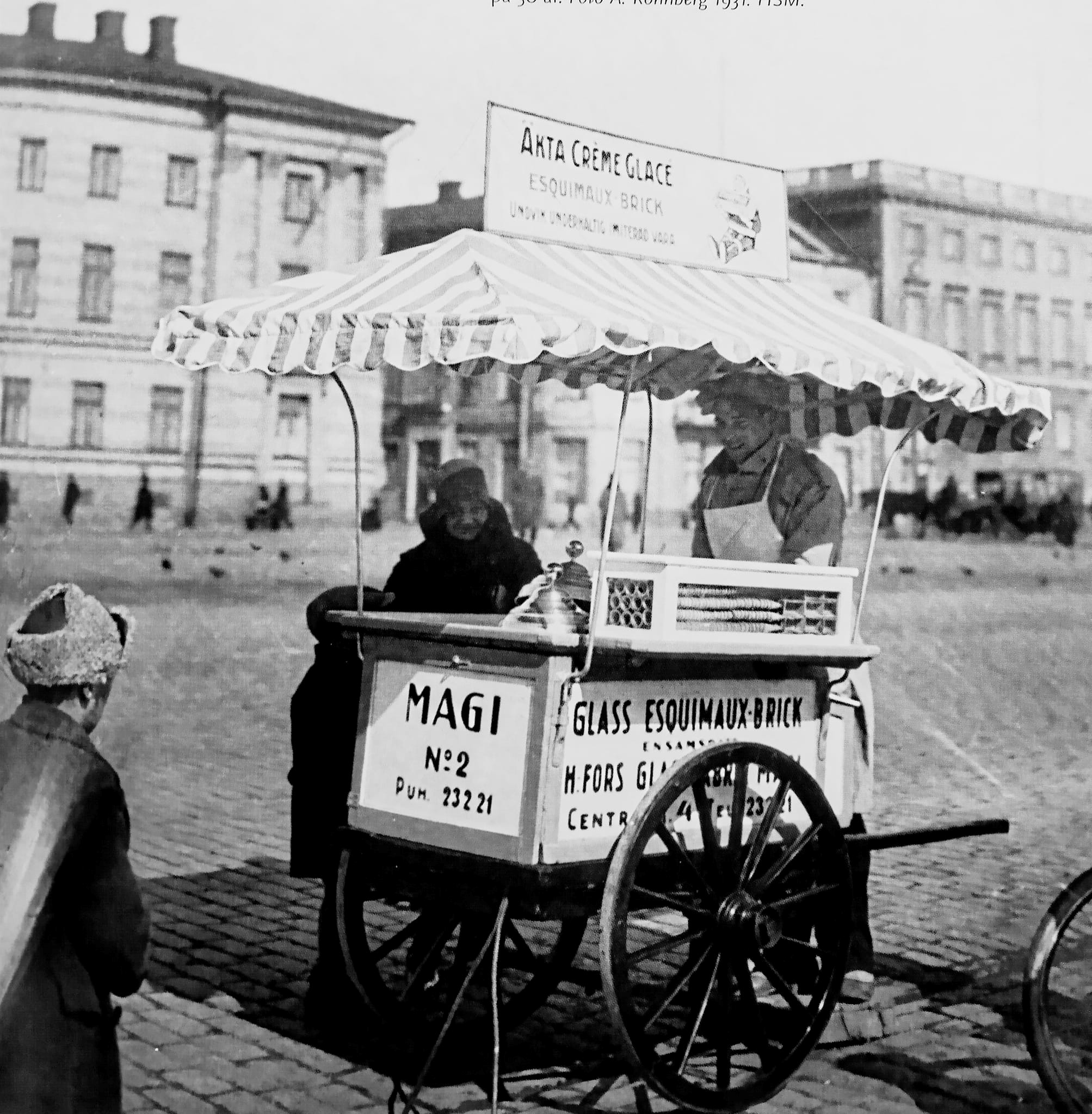 Mustavalkoinen valokuva vanhasta Magin jäätelövaunusta Helsingin Kauppatorilla.