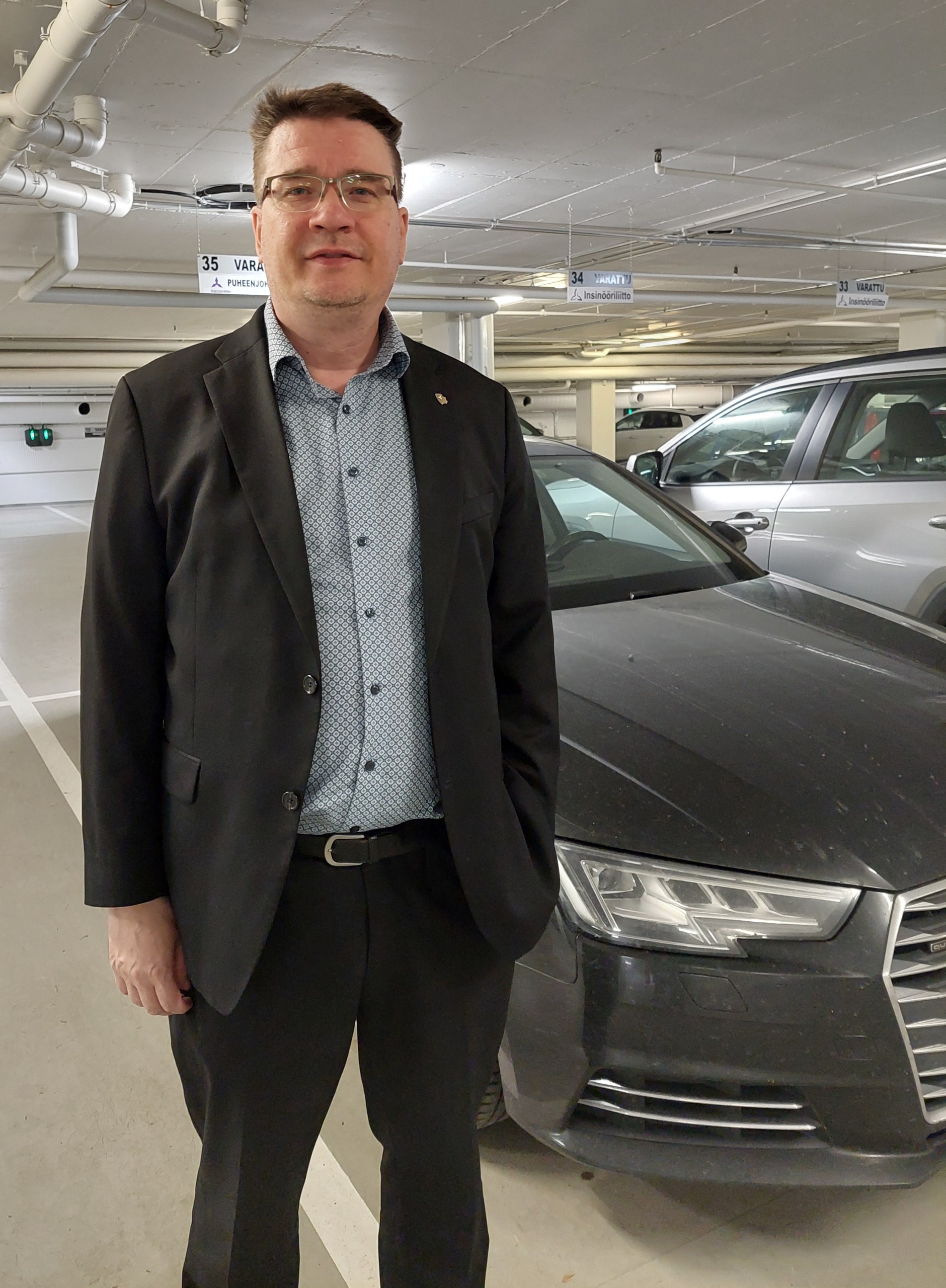 Puheenjohtaja Samu Salo työsuhde-Audinsa edessä.